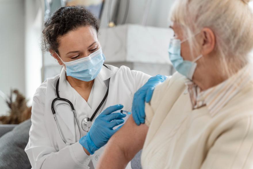 Dokter vaccineert een oudere dame
