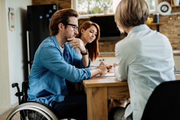 Persoon in een rolstoel komt op consultatie voor financiële steun